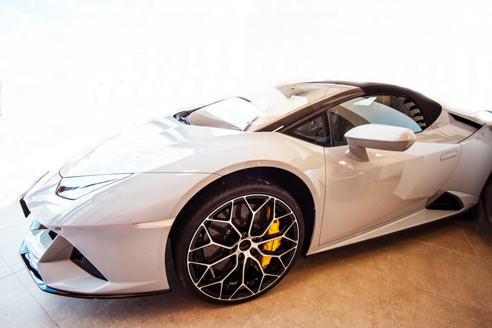 Llanta y pinza de freno amarilla de un Lamborghini Huracán blanco.